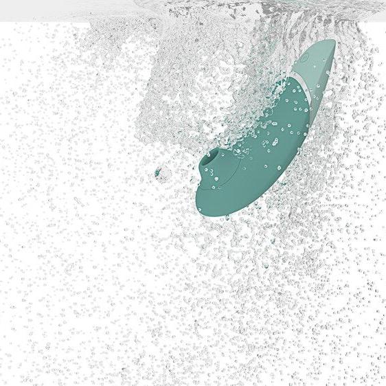Womanizer NEXT sugevibrator i mintgrønn, elegant design med Soft Touch-overflate, under vannsprut.