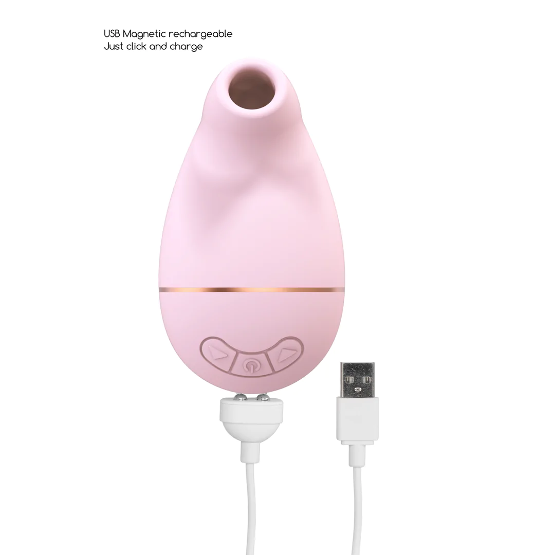Lys rosa silikon sugevibrator med gullfarget bånd, kontrollknapper, og magnetisk USB-ladekabel.