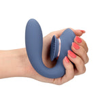 Blå silikon Twitch 3 sugevibrator med trippel stimulering, holdt i en hånd med rosa negler.