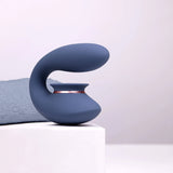 Mørkeblå Twitch 3 sugevibrator i silikon med rosegull aksent, vist på hvit sokkel.