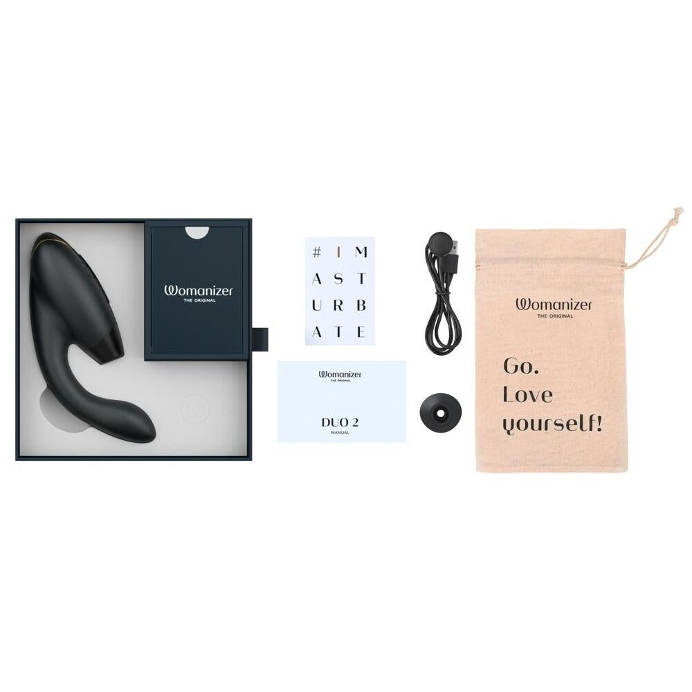 Svart Womanizer Duo 2 klitoris- og G-punktstimulator i åpen eske med lader, manual og beige pose.