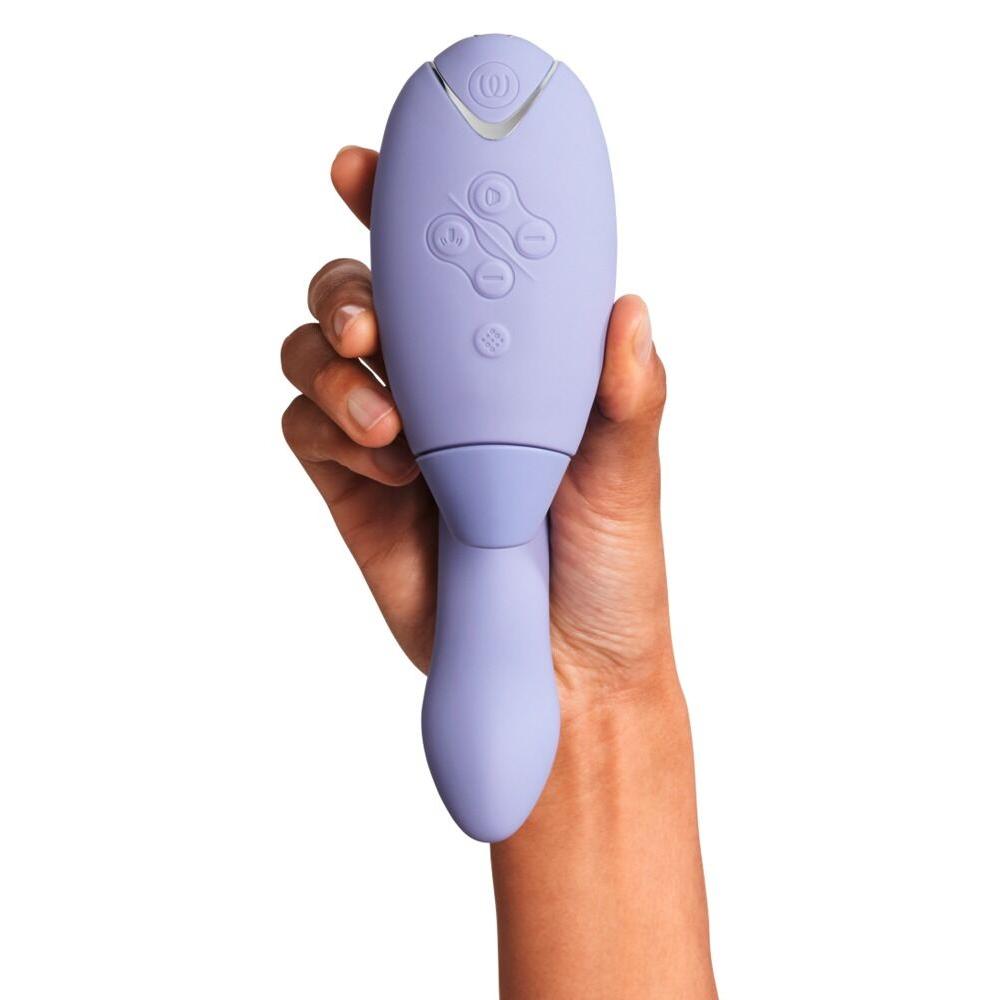 Hånd holder en lilla Womanizer DUO 2 rabbitvibrator med Pleasure Air-teknologi og G-punktstimulering.
