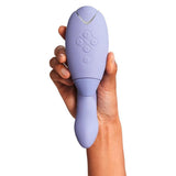 Hånd holder en lilla Womanizer DUO 2 rabbitvibrator med Pleasure Air-teknologi og G-punktstimulering.