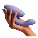 Hånd holder en lilla Womanizer DUO 2 rabbitvibrator i silikon med Pleasure Air-teknologi og G-punktstimulering.