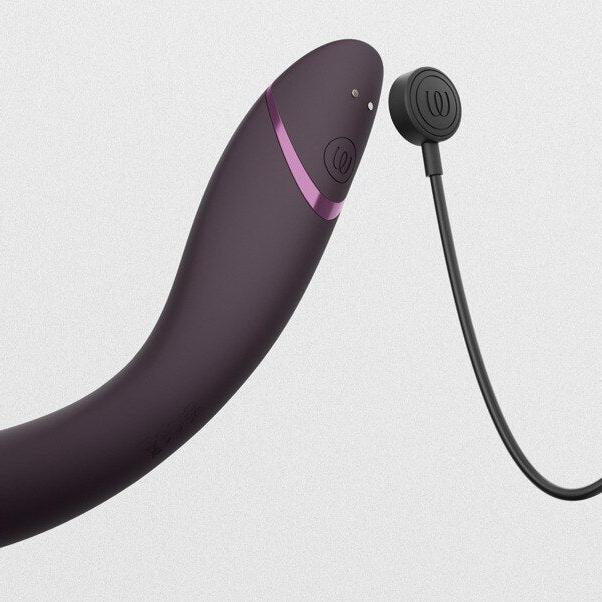 Burgunderrød Womanizer OG G-punktvibrator med Pleasure Air-teknologi og magnetisk ladekabel.