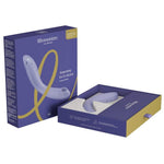 Lilla Womanizer OG G-punktvibrator med Pleasure Air-teknologi, vist i åpen og lukket eske.