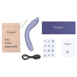 Womanizer OG lilla vibrator, med ladekabel, oppbevaringspose, og eske på hvit bakgrunn.