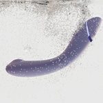 Womanizer OG vibrator i lilla, buet design, nedsenket i vann med bobler.