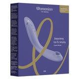 Womanizer OG G-punktvibrator i lilla silikon, med Pleasure Air-teknologi og kontrollknapper, presentert i esken.