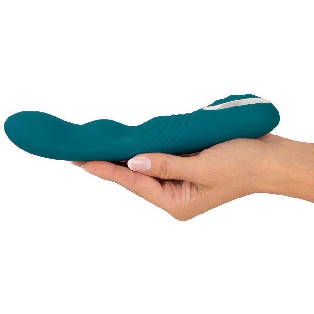 Turkis silikon G-punkt vibrator med roterende spiss, holdt i en hånd.