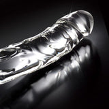 Klar, håndlaget glassdildo med elegant, bølget design og glatt overflate for temperaturlek.