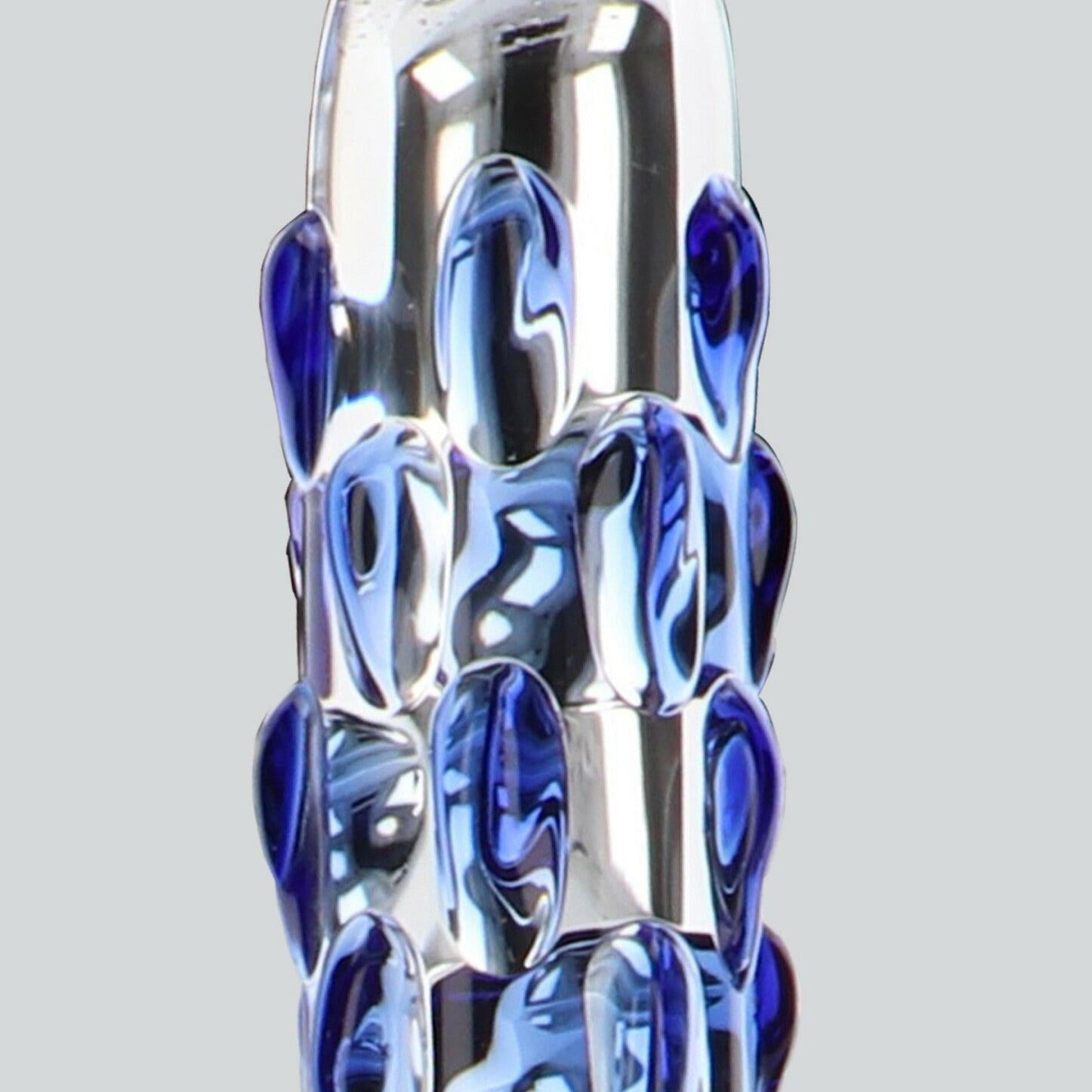 Klar glassdildo med buet silhuett og blå stimulanseknopper.