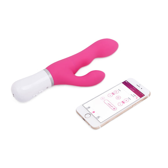 Lovense Nora rabbitvibrator i rosa silikon med hvit base og en smarttelefon som viser app-kontrollen.