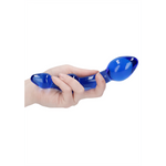 Hånd holder en blå glassdildo med to buler, den ene større enn den andre.