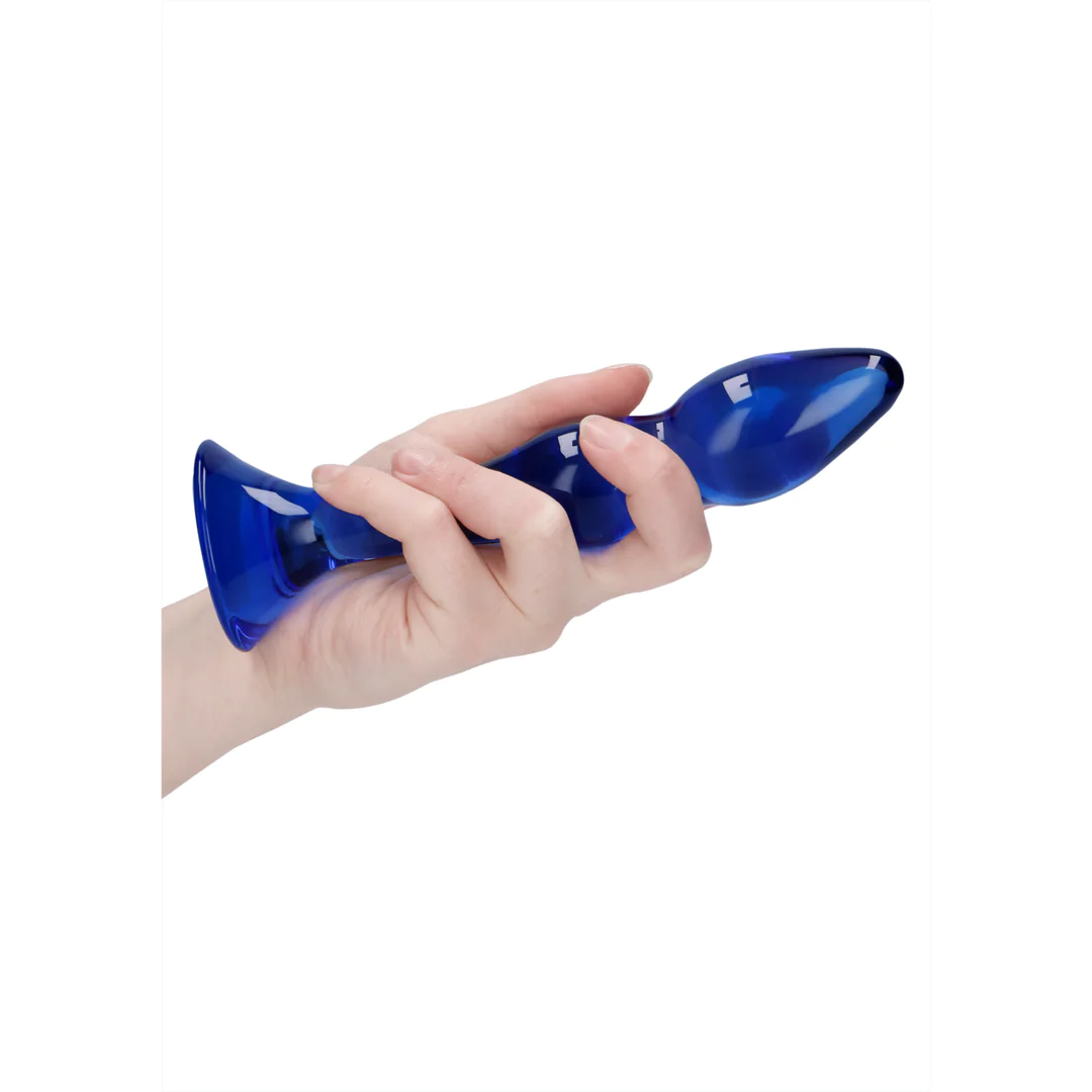 Hånd holder en kurvet, blå Gallant glassdildo med en bred base, perfekt for temperaturlek.