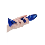Hånd holder en kurvet, blå Gallant glassdildo med en bred base, perfekt for temperaturlek.