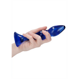 Hånd holder en kurvet, blå Gallant glassdildo med en bred base, perfekt for temperaturlek.