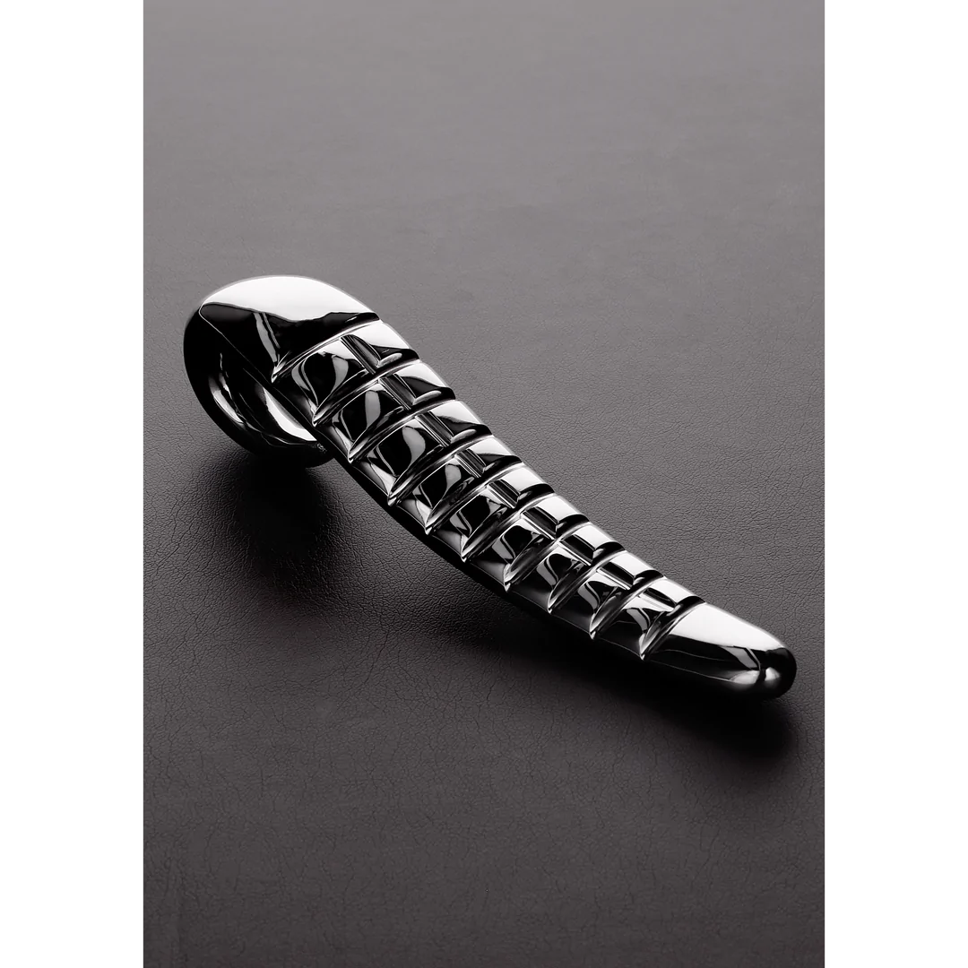 Skinnende Devil Tongue dildo i rustfritt stål med dype, taktile riller og buet håndtak.
