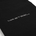 Mr. Steel logo i sølv på en svart tekstiloverflate.