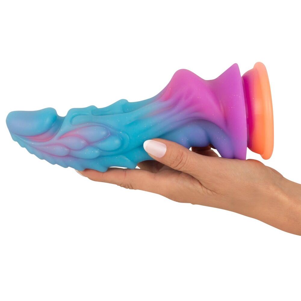 Mystic Dragon fantasydildo i glitrende regnbuefarger, blå, lilla og oransje, holdt i en hånd.