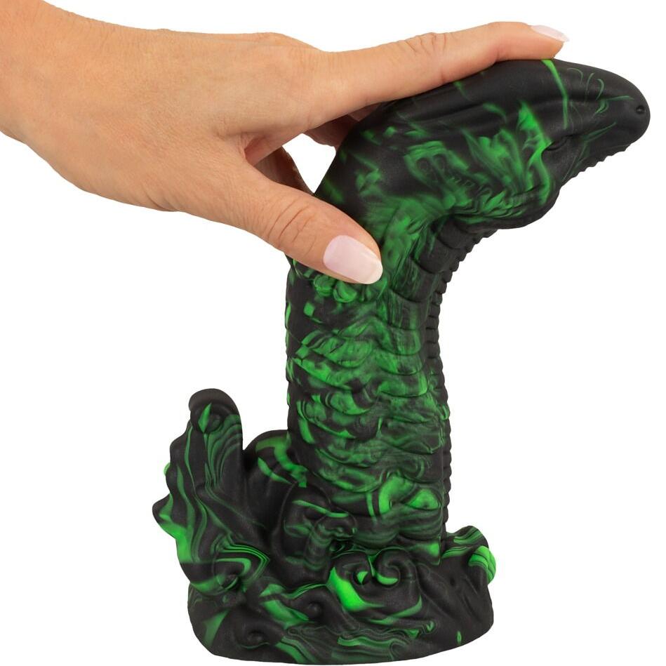 Hånd holder en svart og grønn marmorert Lizard Peak fantasidildo med reptilinspirert design og sugekopp.
