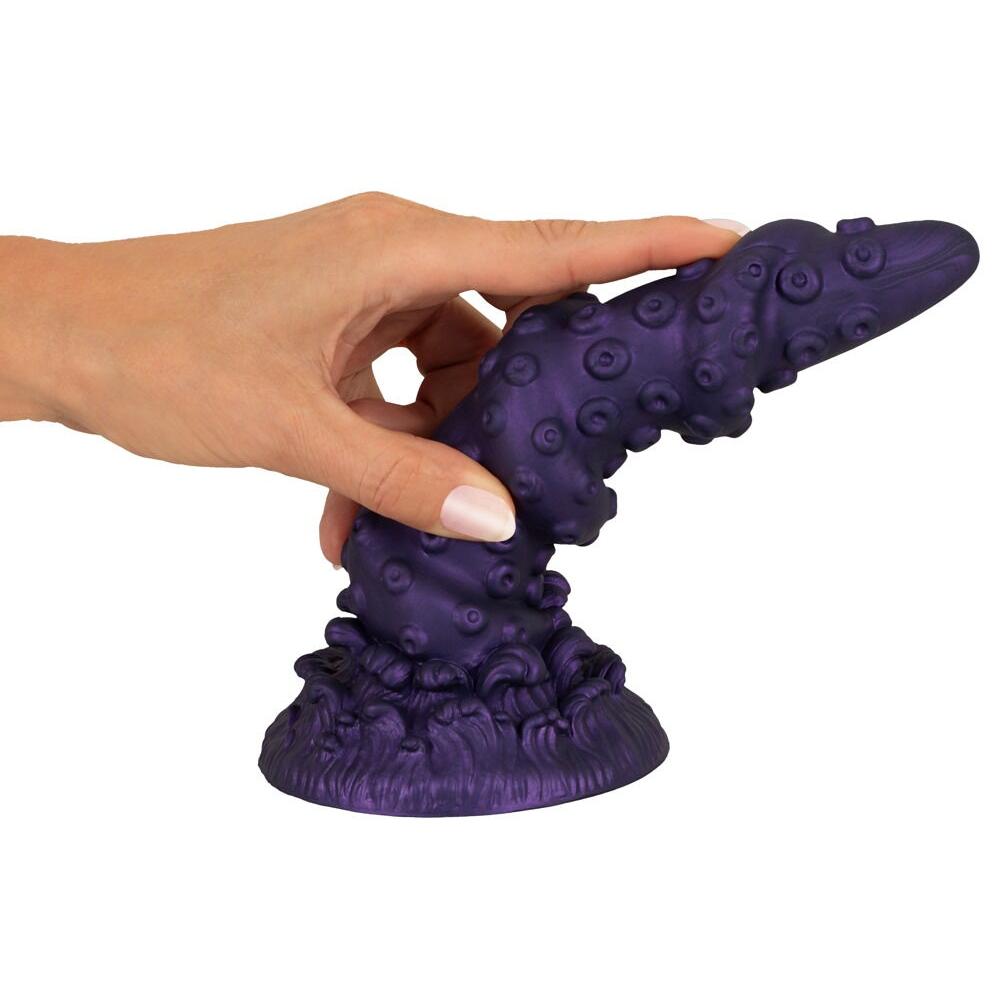 Lilla, tentakelinspirert Octopus Prime fantasidildo med sugekopp, holdt av en hånd.