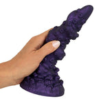 Lilla Octopus Prime fantasidildo i silikon med tentakeldesign og sugekopp, holdt i en hånd.