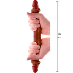 Brun 35 cm dobbeldildo med realistisk forhud, holdt av to hender.