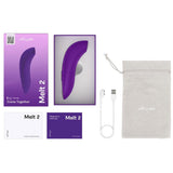 We-Vibe Melt 2 lilla lufttrykksvibrator, eske, ladeledning, bruksanvisninger og oppbevaringspose.