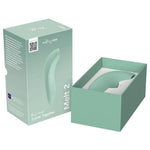 We-Vibe Melt 2 lufttrykksvibrator i dus grønn silikon, vist i åpen og lukket produktemballasje.