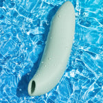 We-Vibe Melt 2 lufttrykksvibrator i dus grønn silikon, dekket av vanndråper på blått vann.